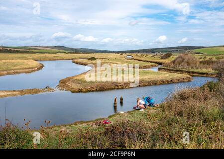 Seaford UK 04 September 2020 - Wanderer genießen heute warmes, sonniges Wetter mit einer Mischung aus Wolken in Cuckmere Haven bei Seaford an der Sussex-Küste. : Credit Simon Dack / Alamy Live News Stockfoto