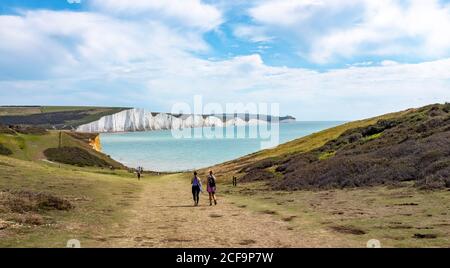 Seaford UK 04 September 2020 - Wanderer genießen heute warmes, sonniges Wetter mit einer Mischung aus Wolken auf den Klippen, die Cuckmere Haven und die Seven Sisters in der Nähe von Seaford an der Sussex-Küste überblicken. : Credit Simon Dack / Alamy Live News Stockfoto