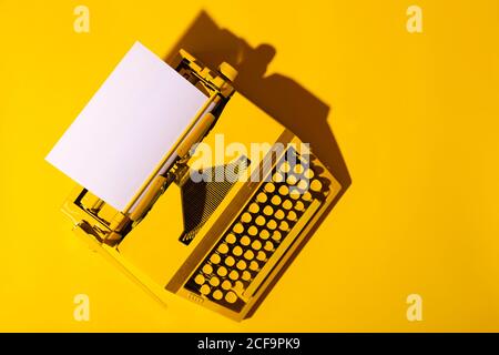 Gelbe helle Schreibmaschine auf gelbem Hintergrund. Kreativitätskonzept Stockfoto