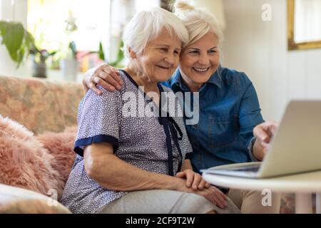 Erwachsene Tochter lehrt ihre ältere Mutter zu verwenden Laptop Stockfoto