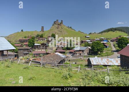 Von unten einsamer alter Turm mit Steinmauern am Stadtrand Von Dorf gegen erstaunliche Aussicht auf grüne bewaldete Hügel und Misty Tal in Georgien Stockfoto