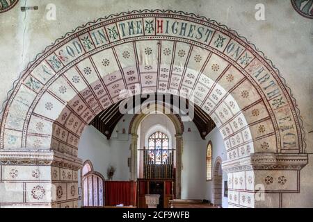 Die normannische Kirche St. George im Cotswold-Dorf Hampnet zeigt den Kanzelbogen aus dem 12. Jahrhundert, der vom Vikar in den 1870er Jahren geschmückt wurde. Stockfoto