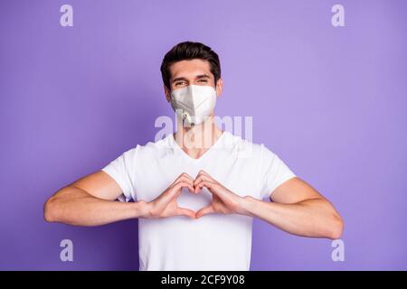 Portrait seiner er schön attraktiv gesund Brunet Kerl zeigen Herzform lieben Sie für immer tragen n95 Atemschutzmaske Pandemia mers-Kov isoliert ein Stockfoto