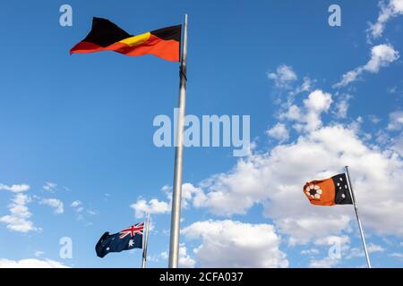 Flaggen flattern, vom Wind bewegt. Drei Flaggen aus Australien, dem Northern Territory und der Aborigine-Flagge. Anzac Hill Memorial, Alice Springs, Australien Stockfoto