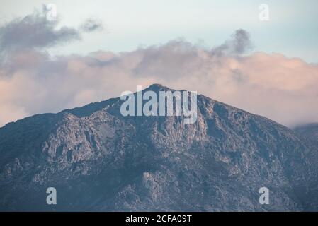 Ruhige Landschaft mit Bergkette bedeckt mit Nebel gegen bewölkt Morgenhimmel in der Herbstsaison Stockfoto