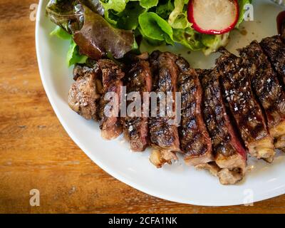 Medium Rare Steak mit gegrillter Feuersoße gekocht. Geschnitten in einer mundgroßen, saftig, schöne Farbe, appetitlich, bestreut mit natürlichem Salz Dekorieren. Stockfoto