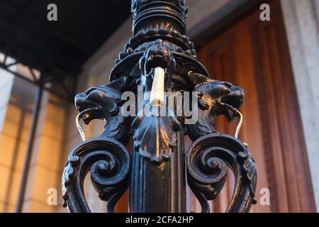 Dekorative geschmiedete schwarze Säule in Form von Greifen oder Katzen Mit goldenen langen Zungen Stockfoto