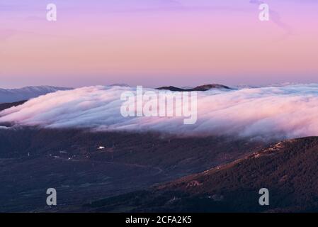 Von oben der Altstadt am Hang des Hügels unter Grüner Wald bedeckt mit dichtem Nebel unter farbenprächtiger Morgenhimmel Stockfoto