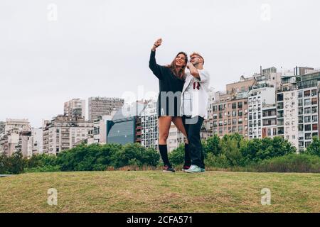 Freunde lächeln, während sie Selfie auf dem Smartphone in der Stadt machen Stockfoto