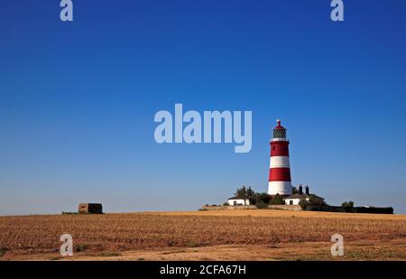 Ein Blick auf den Leuchtturm und den Zweiten Weltkrieg Pille Box von der Klippe oben Weg in North Norfolk in Happisburgh, Norfolk, England, Großbritannien. Stockfoto