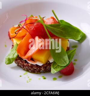 Zartes Lachsfilet auf einem Quinoa-Kissen mit Gemüse. Speisekarte im Restaurant. Weißer Hintergrund. Freier Speicherplatz für Text. Stockfoto