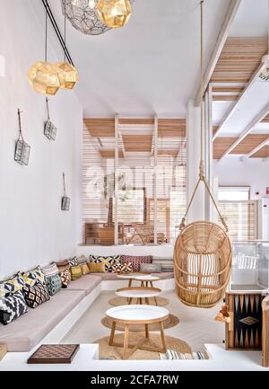 Gemütliches Wohnzimmer mit Holzmöbeln und weißen Wänden mit Geometrische Verzierungen Stockfoto