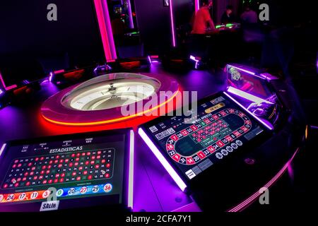 Casino Tisch mit modernen Roulette und digitale Bildschirme beleuchtet von Neonlichter im dunklen Kasino Stockfoto