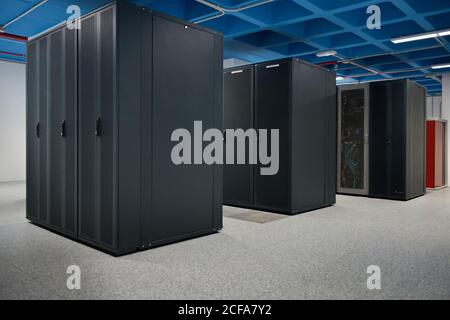Interieur der modernen beleuchteten Anlage mit Metall-Server-Racks platziert In Zeilen Stockfoto
