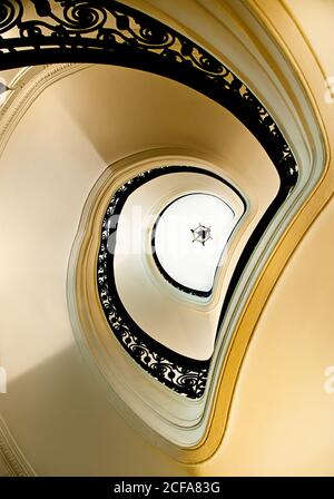 Von unten weiße elegante Wendeltreppe mit schwarzem Ziergeländer Das Hotel liegt im klassischen Gebäude Stockfoto