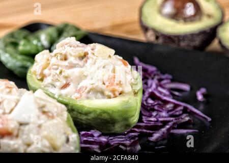 Nahaufnahme von traditionellen leckeren russischen Salat mit gehackten gemischt gekocht Gemüse und Mayo in frisch halbierten Avocado serviert Stockfoto