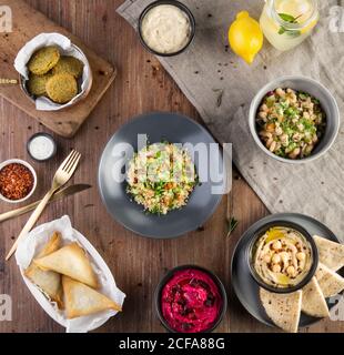 Draufsicht Komposition mit traditionellen türkischen Speisen einschließlich Falafel und Tabbouleh Salat und Gebäck mit Hummus auf Holztisch serviert Stockfoto