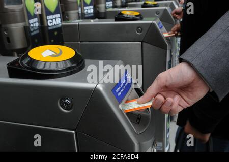 Hand setzen Zug-Ticket in eine TFL-Stationen Ticket Barriere im Großraum London. Stockfoto