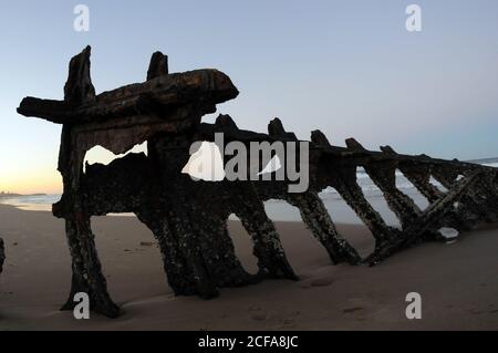 Verfallendes, rostetes Schiff zerstörte den Rumpf eines Teils, der auf einem australischen Strand begraben wurde. Stockfoto