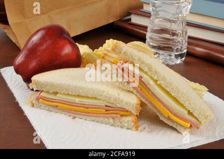 Ein bologna und Käse Sandwich Sack Mittagessen mit einem Apfel, Kartoffelchips und Wasser in Flaschen Stockfoto