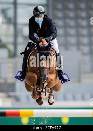 04. September 2020, Nordrhein-Westfalen, Aachen: Eric Lamaze, ein Springreiter aus Kanada, springt beim Internationalen Springwettbewerb Aachen mit Mund-Nase-Schutz während des Springwettbewerbs mit Stechen über ein Hindernis. Foto: Rolf Vennenbernd/dpa Stockfoto