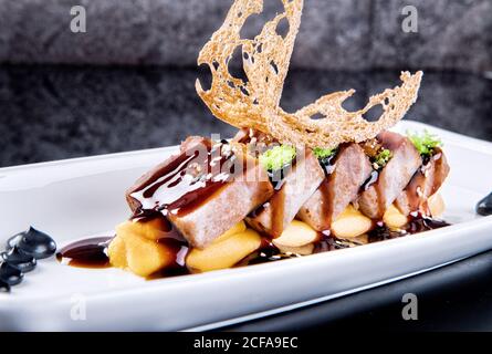 Nahaufnahme von köstlichen Thunfisch Stücke mit garniert mit Kaviar und unagi-Sauce auf weißem Teller in teurem Restaurant serviert Stockfoto