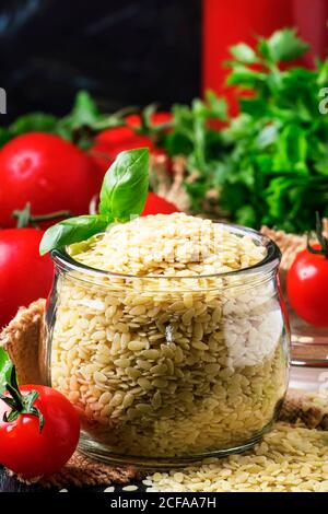 Italienische Pasta orzo in Form von Reis in Glas, selektive Fokus Stockfoto