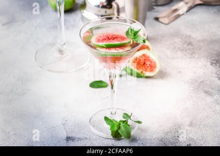 Pink Fig martini Cocktail aus Schnapsglas auf grauem Tisch mit Bar-Tools, selektiver Fokus Stockfoto
