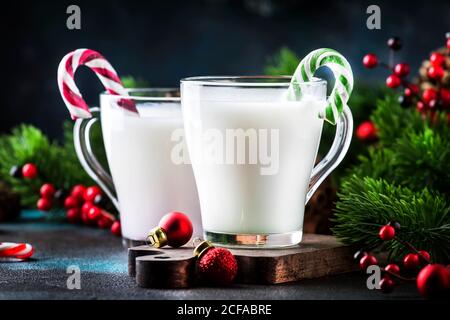 Heißer Winter-Weißgetränk mit Candy Sticks, Weihnachten oder Neujahr Dekorationen, dunkler Hintergrund, rustikalen Stil, Kopierraum Stockfoto