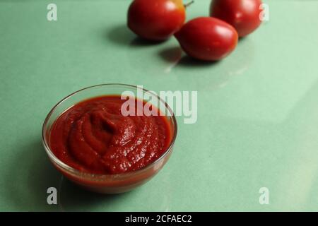Rote Tomatensauce in einem Topf im Hintergrund sind Gemüse rote Tomaten auf grünem Hintergrund mit einer Kopie Platz Stockfoto