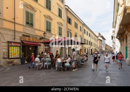 Menschen, die in einem Straßencafé auf dem Corso Italia, einer Fußgängerzone im Zentrum von Pisa, Italien, spazieren gehen und sich ausruhen Stockfoto