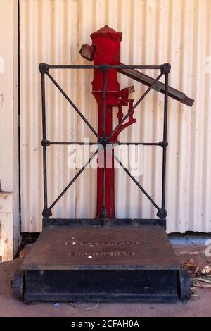 Vintage-Waage zum Gewichten von Gepäck und Personen. Rote Farbe. Gefunden am alten Bahnhof, Pine Creek, Stuart Highway, Northern Territory NT, Australien Stockfoto