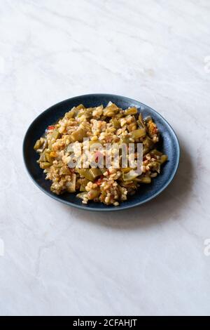 Türkische Olivenöl Lebensmittel Grüne Erbsen / Fasulye Diblesi oder Ayse Kadin Dible mit Bulgur / Bulgur Reis serviert in Teller traditionelle gesunde Bio-Lebensmittel. Stockfoto