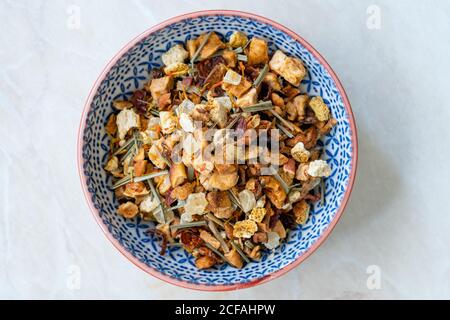 Erfrischender, trockener Tee, Satsuma, Ananas und Apfel in Schale, serviert im Sommer zu kaltem Tee. Fertig zum Kochen. Stockfoto