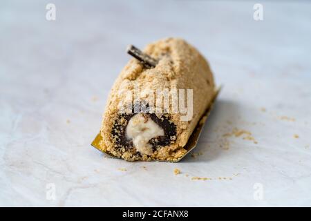 Arctic Cake Milky Roll Dessert mit Biskuitpulver und Banane. Bereit zu servieren und zu essen. Stockfoto