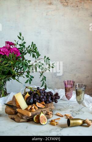 Affen neben einem Stück Käse auf Schneidebrettern in der Nähe Rosa Blüten Stockfoto