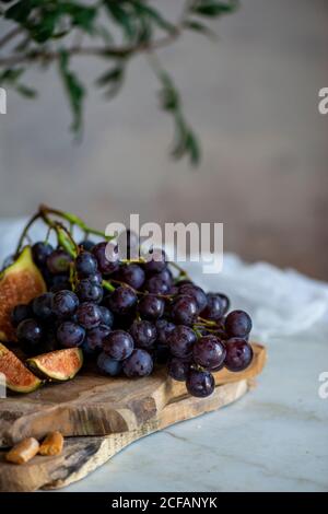 Affen neben einem Stück Käse auf Schneidebrettern in der Nähe Rosa Blüten Stockfoto