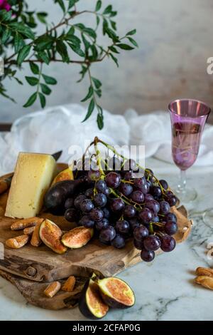 Affen neben einem Stück Käse auf Schneidebrettern in der Nähe Rosa Blüten Stockfoto