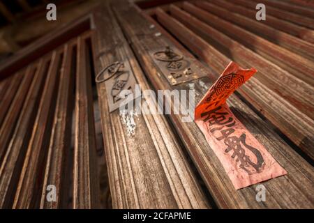 Unten von der alten hölzernen Tür mit den Metallklopfern und Roter Aufkleber mit Hieroglyphen in Daimei Village Stockfoto
