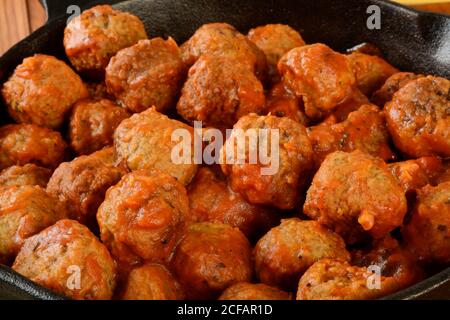 Nahaufnahme von italienischen Fleischbällchen in Marinara-Sauce in einem Guss Eiserne Pfanne Stockfoto