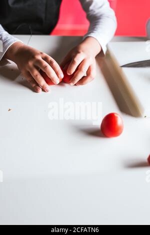 Anonymer Junge Auswahl der Zutaten für die Zubereitung eines gesunden Salats in Küche Stockfoto