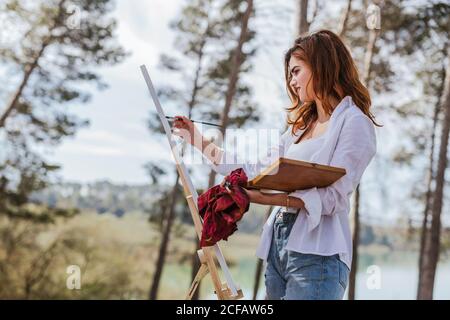 Junge Frau malt auf dem Land Stockfoto