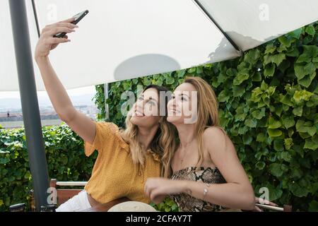 Eine Gruppe von Freunden trinkt Bier und redet auf der Terrasse Einer Bar an einem sonnigen Tag Stockfoto