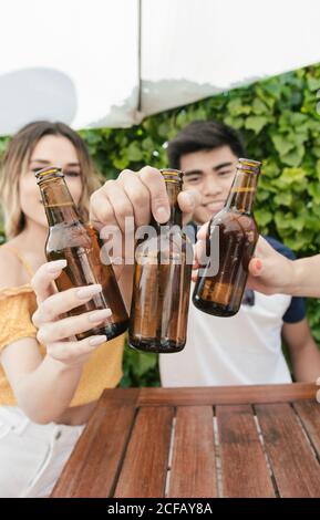 Eine Gruppe von Freunden trinkt Bier und redet auf der Terrasse Einer Bar an einem sonnigen Tag Stockfoto