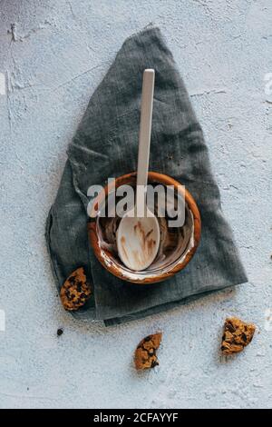 Von oben Stücke von leckeren Haferflocken Cookies auf Putz gelegt Oberfläche neben Tuch Serviette und leere Schüssel mit Flecken von Eis und Löffel Stockfoto