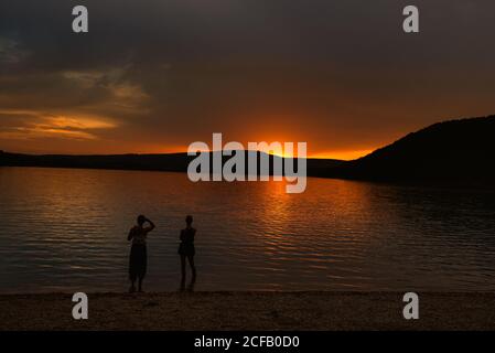 Sonnenuntergang über dem Chalain See mit zwei Damen bewundern die Aussicht, Frankreich Stockfoto