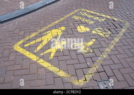 Gelbe Schilder auf der Straße weisen auf einen Shared Space Bereich in Amsterdam hin, ein Konzept, bei dem es an Priorität und Regeln für den Verkehr mangelt. Konzentrieren Sie sich auf die Schilder Stockfoto