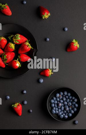 Verschiedene frische Früchte auf schwarzem Hintergrund platziert Stockfoto