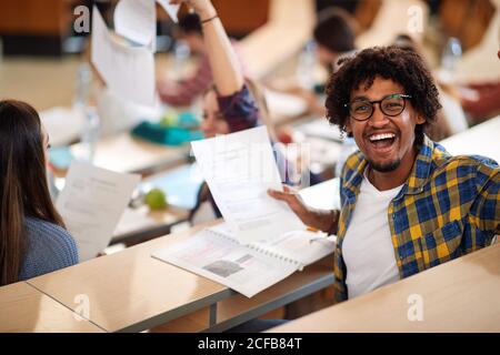 Sehr glücklich männlichen Schüler im Amphitheater mit seinem Erfolg auf Abschlussprüfung Stockfoto