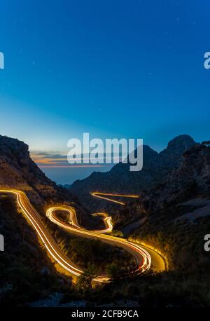Lange Belichtungsstraße in der Nacht zwischen Bergen Stockfoto
